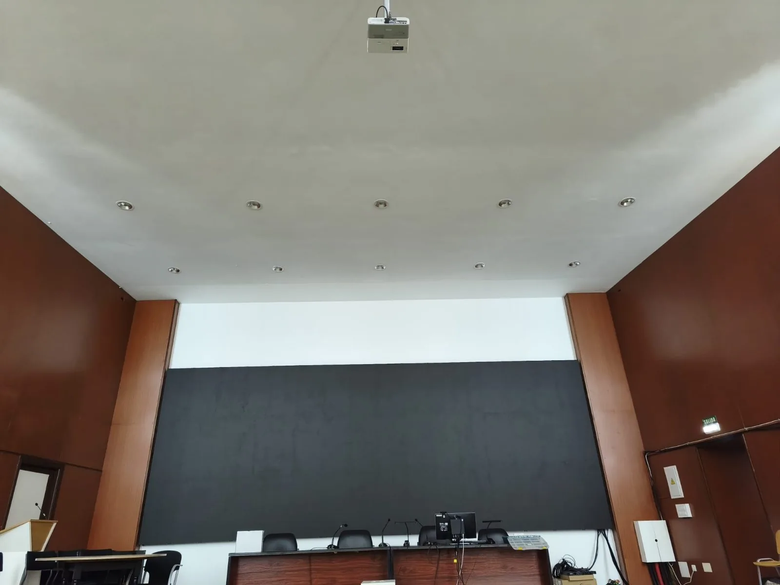 Sala con pantalla LED, proyector en el techo y focos empotrados