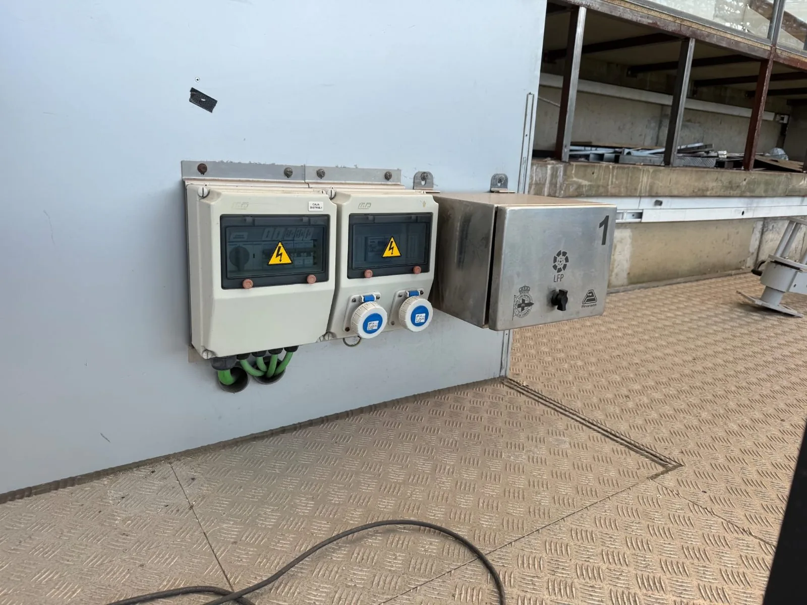 Cuadros de enchufes industriales y caja de conexión instalados en una grada